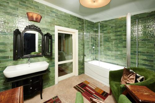 a bathroom with green tiled walls and a sink and a tub at Faik Pasha Hotels Special Category Beyoglu Istanbul in Istanbul