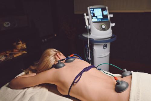 a woman laying on a bed in front of a medical machine at Grand Hotel Velingrad in Velingrad