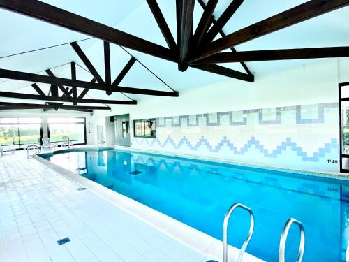 uma grande piscina com água azul em Holiday Inn Calais Coquelles, an IHG Hotel em Coquelles