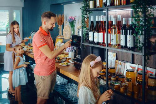 een man staat met twee meisjes aan een toonbank in een winkel. bij Zacisze Nad Nidą Resort in Pińczów