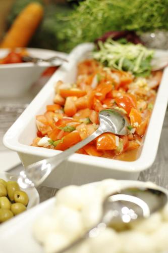 a container of food with a spoon in it at H+ Hotel Salzburg in Salzburg
