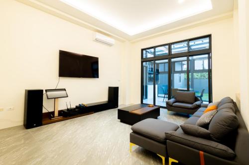 a living room with a couch and a tv at 和你民宿 in Xincheng