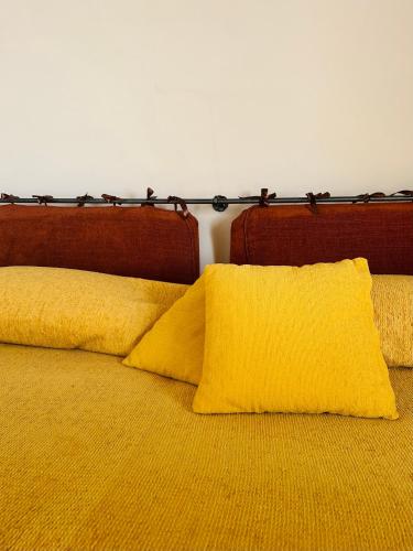 a bed with two yellow pillows on it at Podere La Branda in Vetralla