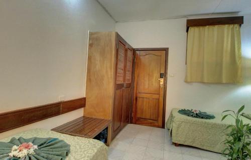 a room with two beds and a wooden door at Honiara Hotel in Honiara