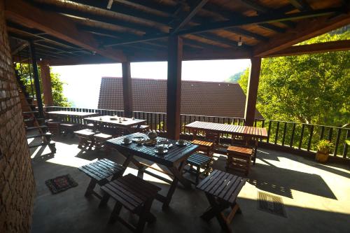 a patio with tables and chairs on a balcony at Ella Camelot in Ella