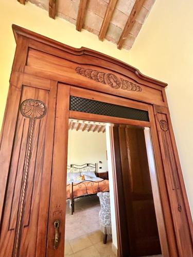 a wooden door leading into a bedroom with a bed at Podere La Branda in Vetralla