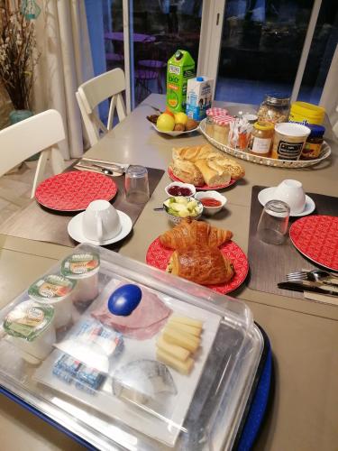 una mesa cubierta con comida y platos de comida en Chambres d'hôtes Villa de Vienne-en-Arthies, en Vienne-en-Arthies
