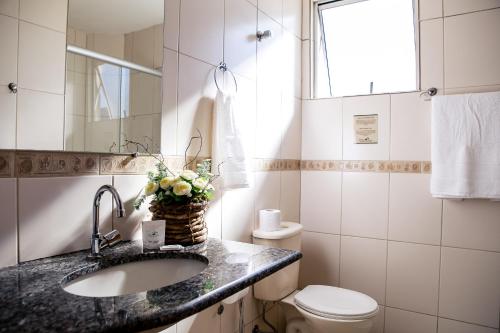 a bathroom with a sink and a toilet at Pousada Sossego da Pampulha in Belo Horizonte