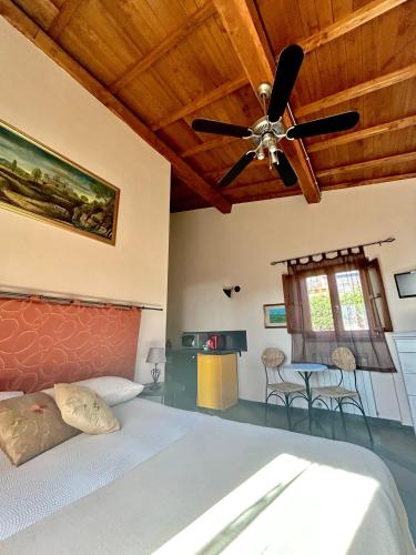 Podere La Branda في فيترالّا: غرفة نوم بسرير ومروحة سقف