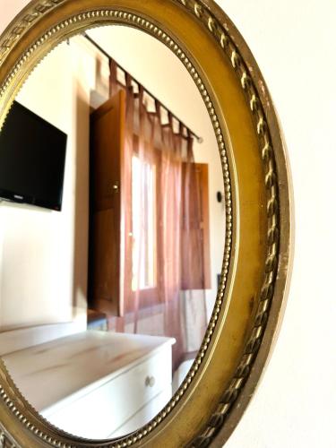 a gold mirror reflecting a living room with a television at Podere La Branda in Vetralla