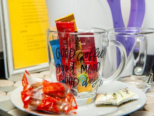 una taza de vidrio llena de dulces en un plato en NN Jacaranda Guesthouse, en Newcastle