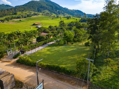 an aerial view of a park with mountains in the background at Seu Refúgio Rural Piscina Privativa e Natureza in Tubarão