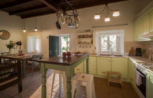 a kitchen with green cabinets and a table in it at Castelli Cottage in Acharavi