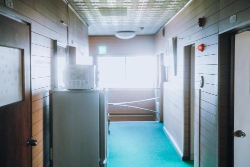 un couloir vide avec un réfrigérateur dans la chambre dans l'établissement ゲストハウス＆カフェバー　エストアール, à Shibetsu