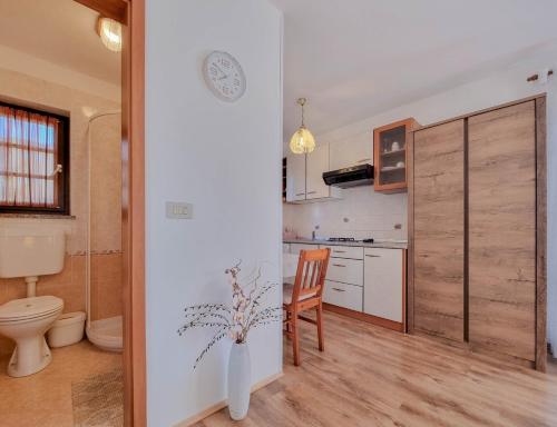 une petite cuisine avec des toilettes et une table dans l'établissement Santo, à Novigrad