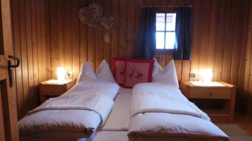 two beds in a room with two lights on them at Chalet Wildgall in Anterselva di Mezzo