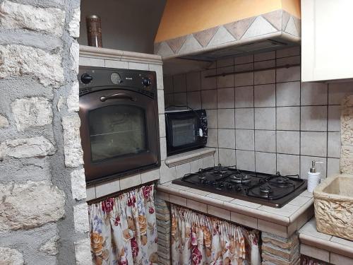 eine Küche mit einem Herd und einer Mikrowelle in der Unterkunft Nel cuore della maiella in Palombaro