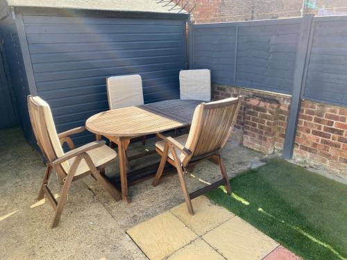 un tavolo e sedie in legno su un patio di 2 bedroomed house close to Cleethorpes seafront a Cleethorpes