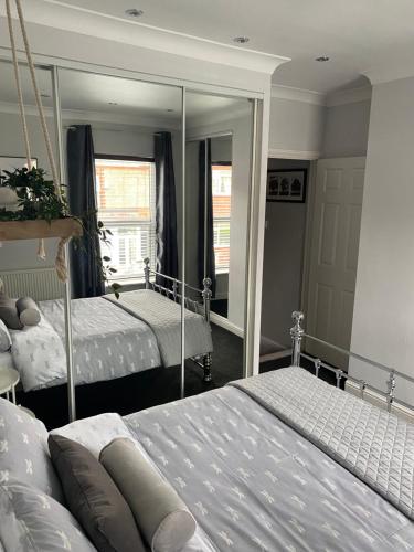 a bedroom with two beds and a large mirror at 2 bedroomed house close to Cleethorpes seafront in Cleethorpes