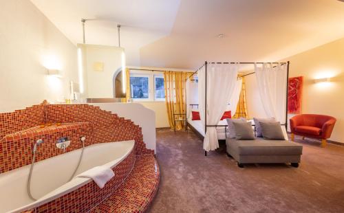 a large bathroom with a tub and a chair at VÖTTER'S HOTEL in Kaprun - summer card included in Kaprun