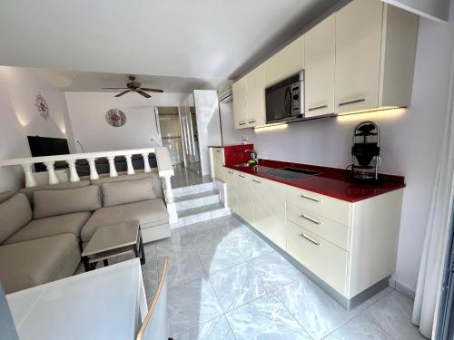a kitchen and living room with white cabinets and a couch at Beachhouse La Palma in Costa Calma