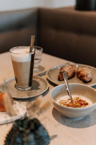 a table with plates of food and a cup of coffee at Hotel Garni Katnau in Schenna