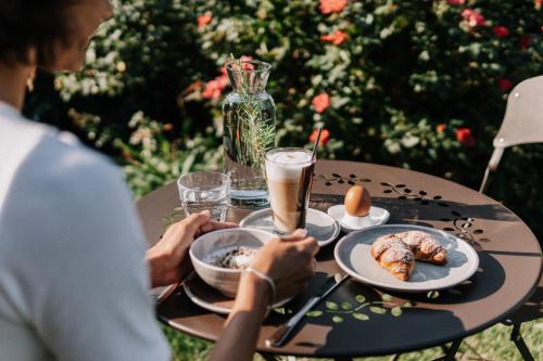 a woman sitting at a table with food and drinks at Hotel Garni Katnau in Schenna