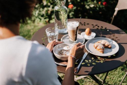 a person sitting at a table with a plate of food at Hotel Garni Katnau in Schenna