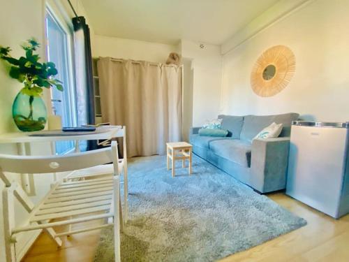 un salon avec un canapé bleu et une table dans l'établissement La Terrasse, Train Lens - Paris trajet d'environ 1 heure 10 minutes, à Lens