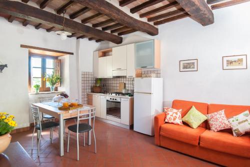 a kitchen and living room with a couch and a table at Appartamento Stalla - Cortona in Corgna