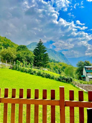 a wooden fence with a field and mountains in the background at Villa Dardania in Peje