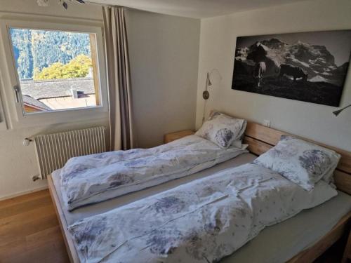 2 Betten in einem Zimmer mit Fenster in der Unterkunft Viola 2 Bett Wohnung in Wengen