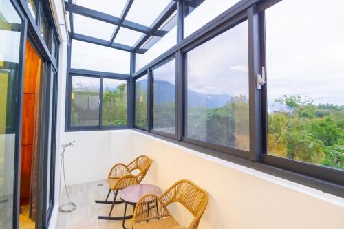 a room with windows and chairs with a view at 和你民宿 in Xincheng