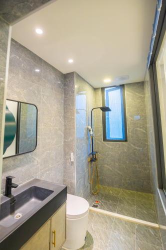a bathroom with a sink and a toilet and a shower at 和你民宿 in Xincheng