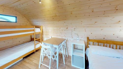 domek z dwoma łóżkami i stołem w obiekcie Camping Pods Sand Le Mere w mieście Tunstall