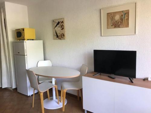 - une cuisine avec une table, une télévision, une table et des chaises dans l'établissement STUDIO SAINT MANDRIER, à Saint-Mandrier-sur-Mer