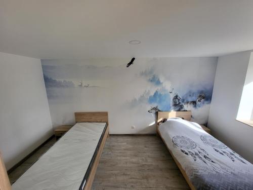 een slaapkamer met 2 bedden en een schilderij aan de muur bij Gites les Gambes in Échenoz-le-Sec