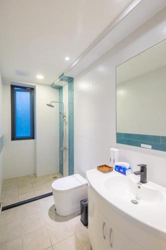 a bathroom with a sink and a toilet and a shower at 和你民宿 in Xincheng