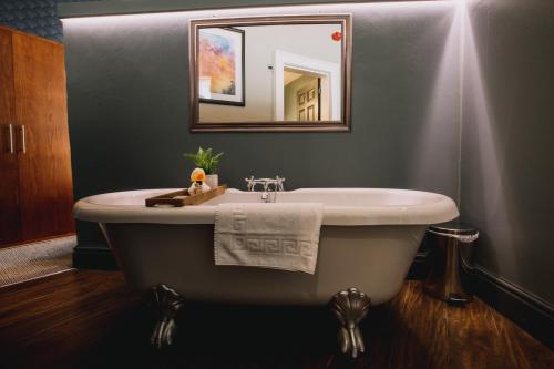 y baño con bañera, lavabo y espejo. en The Sun Hotel & Bar en Lancaster