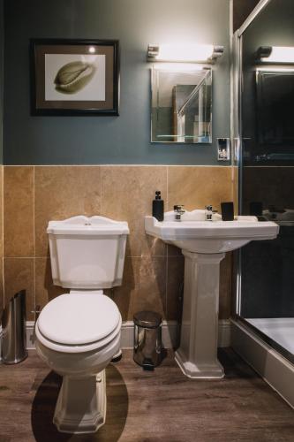 a bathroom with a toilet and a sink at The Sun Hotel & Bar in Lancaster