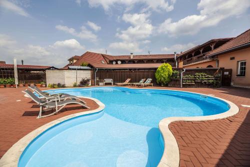 Uničov的住宿－Hotel Aldo，一座房子旁的游泳池,配有两把躺椅