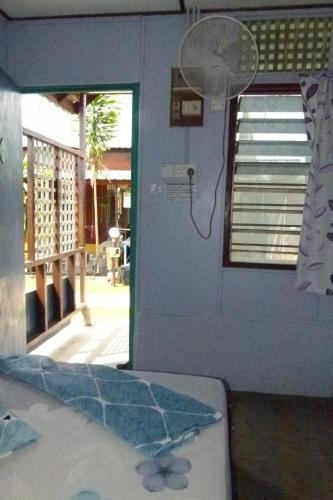 a room with a window and a fan in a room at Cheers Garden Chalet in Kampung Tekek