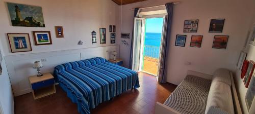 una camera con letto e porta per l'oceano di Villa Le Sprizze a bordo del mare - Goelba a Marciana Marina