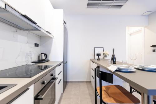 a kitchen with white cabinets and a counter top at Kaleo Chios Luxury Apartments in Chios