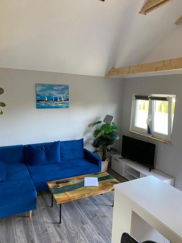 a living room with a blue couch and a table at Bajkowe Domki Marzeń Krecik in Węgorzewo