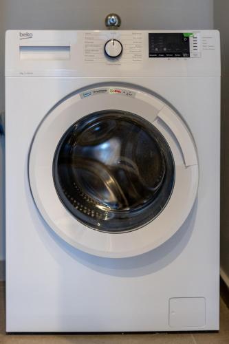 a white washing machine with a black door at Kaleo Chios Luxury Apartments in Chios