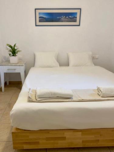 Un dormitorio con una gran cama blanca en una habitación. en San Constantine, en Ornos