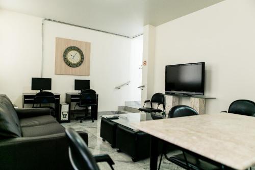 a living room with a couch and a tv at Pousada Sossego da Pampulha in Belo Horizonte