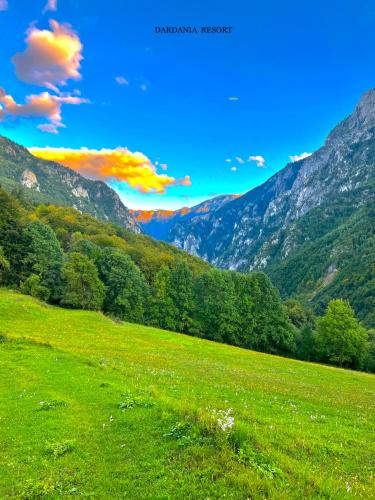 a field of green grass with mountains in the background at Villa Dardania in Peje