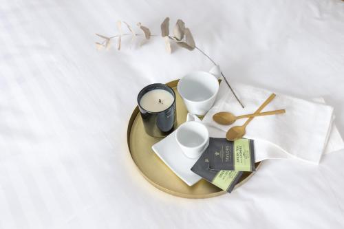 a table with a plate with cups and a book at Kaleo Chios Luxury Apartments in Chios